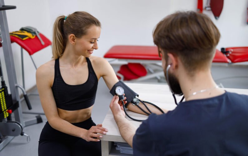 Female athlete undergoes an exercise tolerance test with a cardiologist physiotherapist. 
Measurement of pressure before training