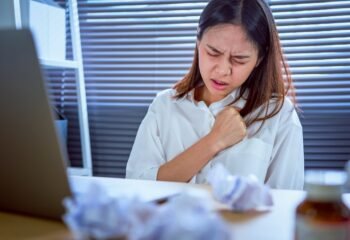 Asian business woman hand pressing on chest with painful expression. Symptoms of heart disease because working too hard.